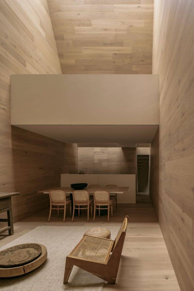 Emma House by HW Studio: A luminous tribute to serenity and space Contemporary minimalist dining room with wood-paneled walls and modern furniture design.