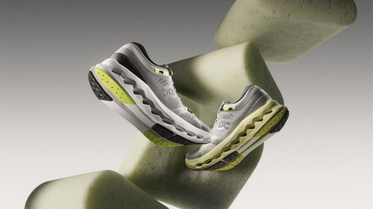 Lightweight athletic running shoes with cushioned sole and modern design on abstract geometric background.