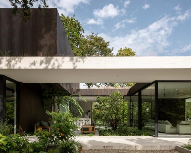Hidden Villa by i29 Architects a modern Dutch home immersed in nature Modern minimalist house with large glass windows and lush greenery outdoor space.