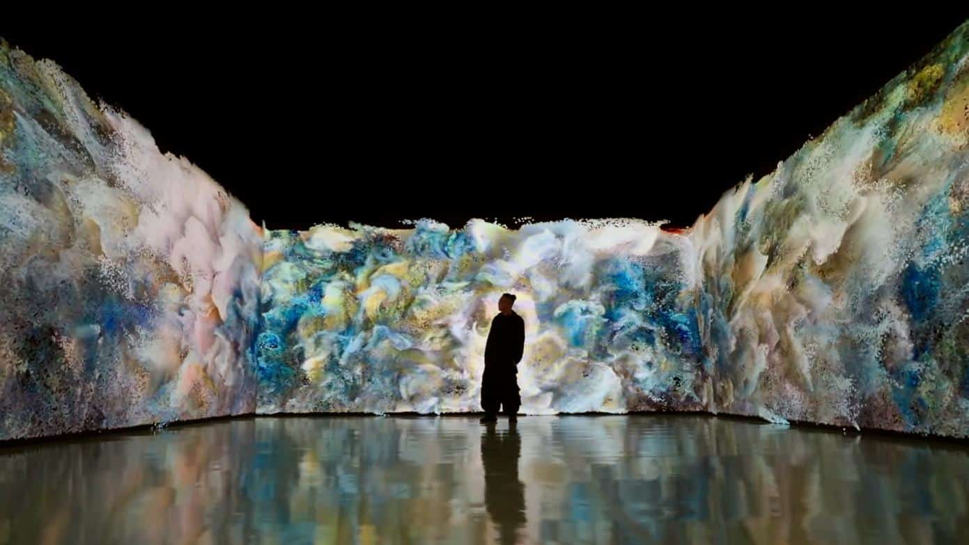 Vivid digital art installation with colorful abstract visuals and a silhouetted person exploring the immersive environment.
