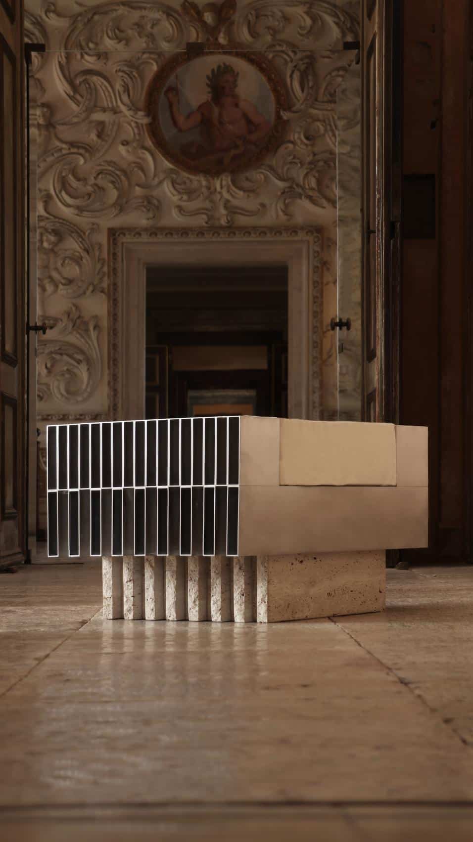 Contemporary abstract sculpture with geometric design in a historic palace interior, blending modern art with classical architecture.