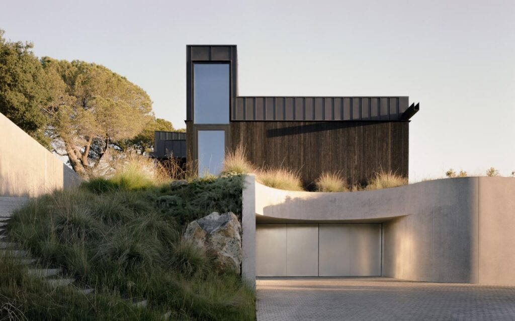 Sunken courtyard connecting subterranean chambers to the natural hillside landscape at the House of Horns