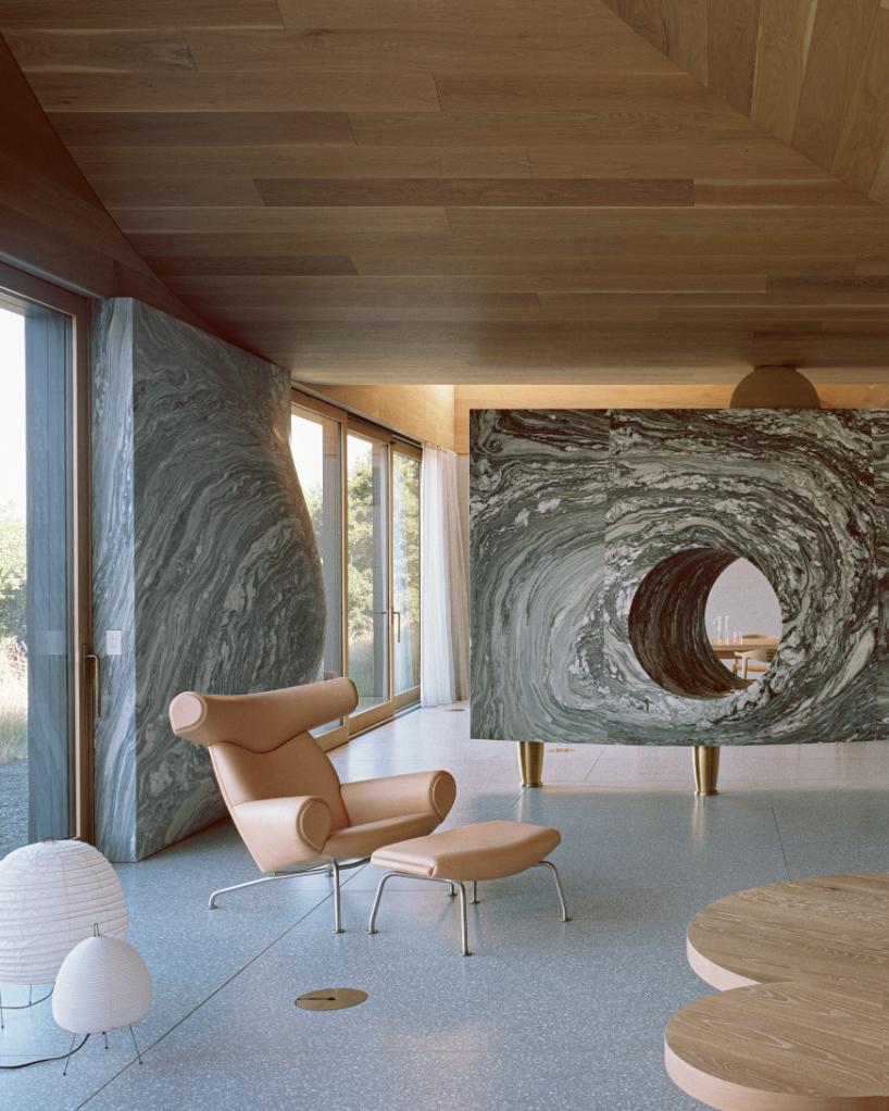 Stone fireplace made from Vermont Danby marble at the center of the open living space in the House of Horns