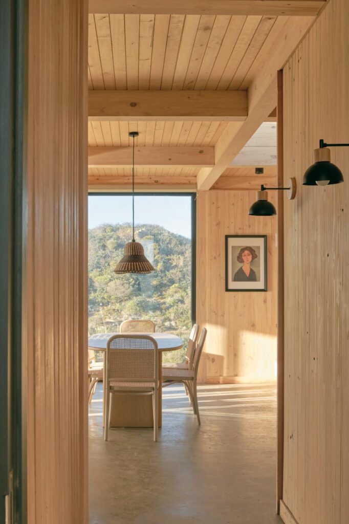 Interior view featuring minimalist decor, large windows, and unobstructed coastal vistas at CR House