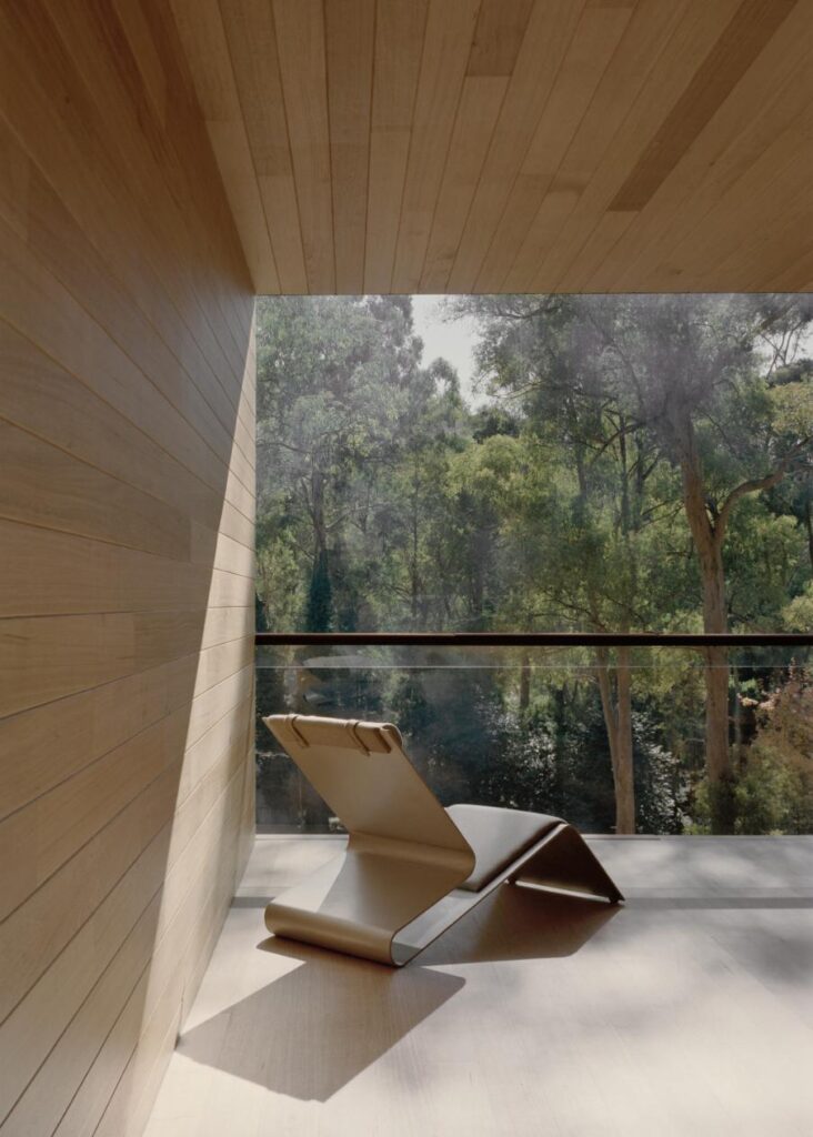 Sunlight filtering through steel slats casting patterned light inside timber-lined ceiling of treehouse