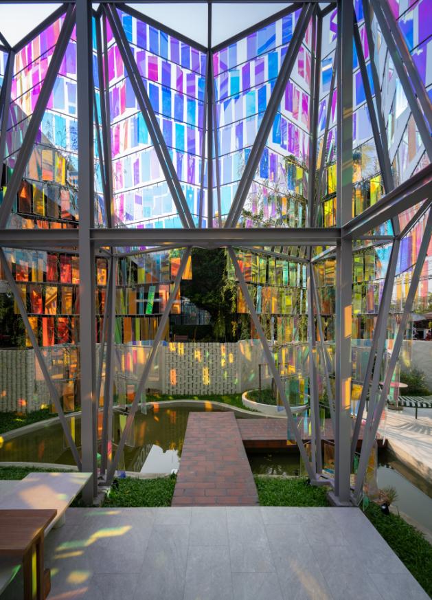 Iridescent acrylic façade reflecting sunlight like a gem