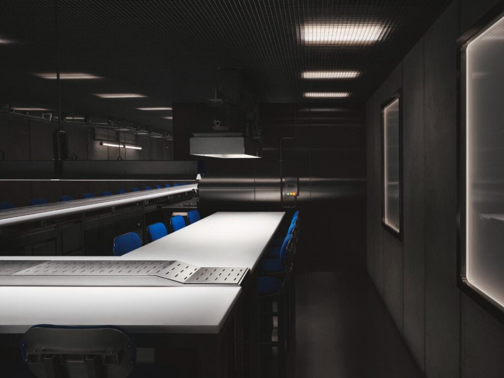 Custom-designed dining chairs arranged under tables in the interior of Sala de Despiece Madrid