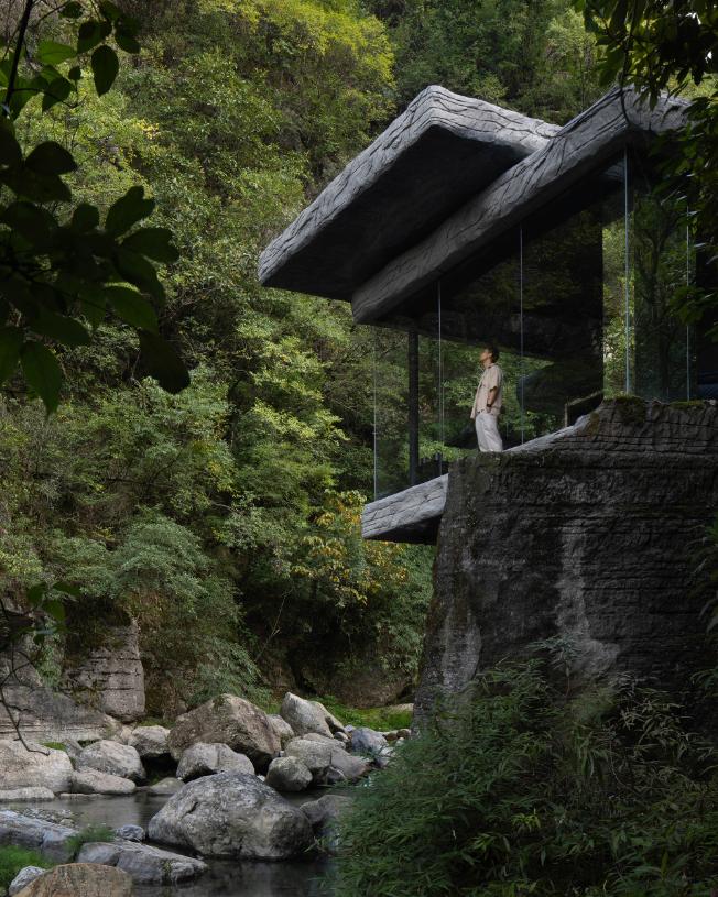 Glass-walled room beneath stone steps at Drifting Stones by DoDesign
