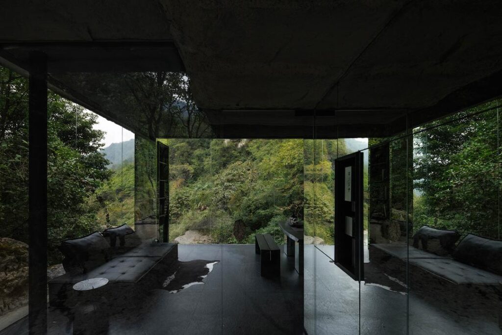 Mirrored hut reflecting trees in secluded forest setting