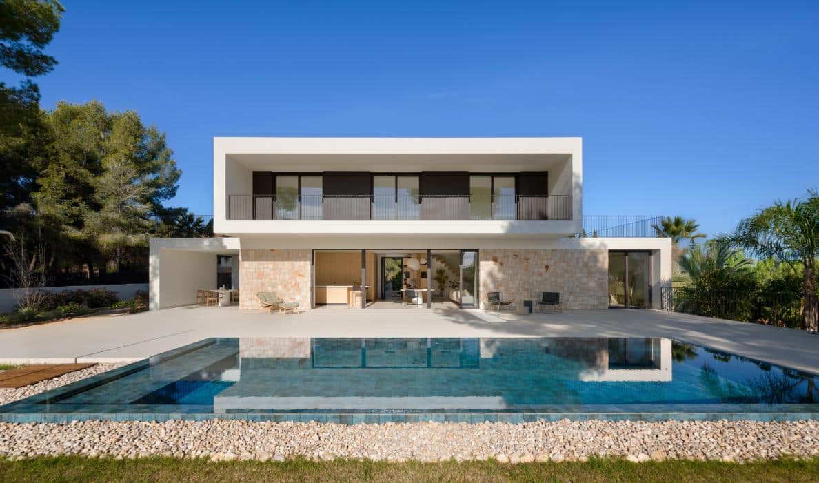 Modern luxury house with pool and contemporary architecture, surrounded by lush greenery.