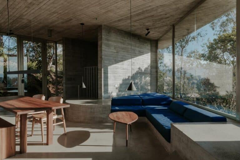 Atelier García designs Concrete House in serene dialogue with the landscape Modern minimalist interior with large glass windows and concrete accents at Visual Atelier 8.