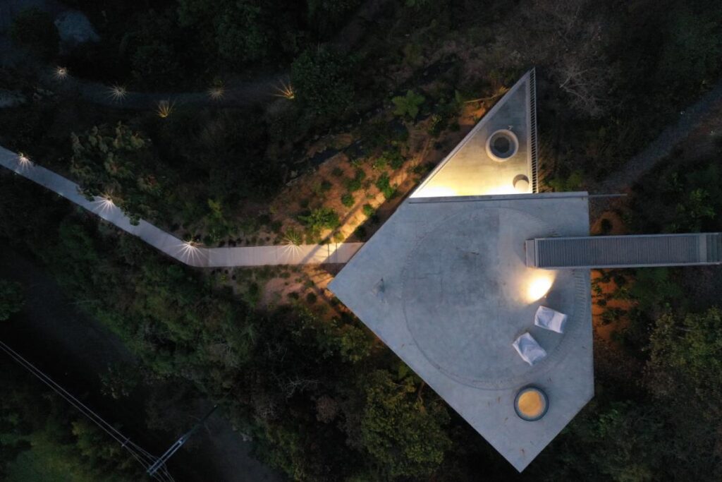 Aerial view of modern concrete residence blending with the mountainous terrain