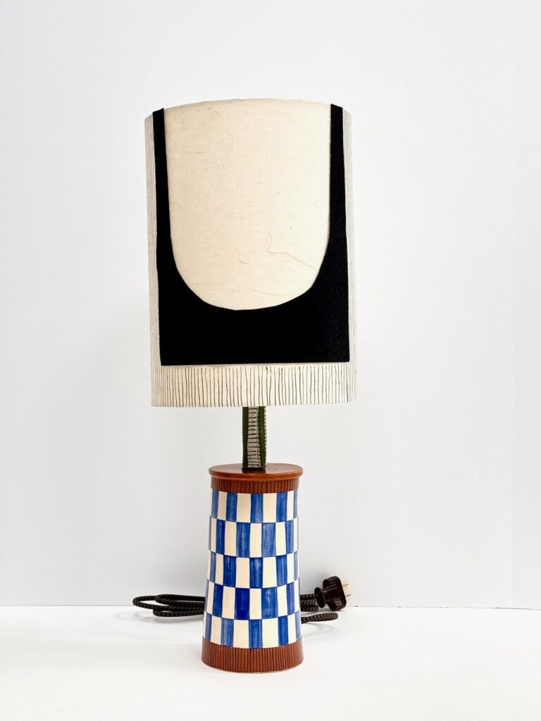 Ceramic lamp by Hadiya Williams featuring organic shapes and earth-toned glaze, displayed on a white pedestal at Art of Noize gallery.