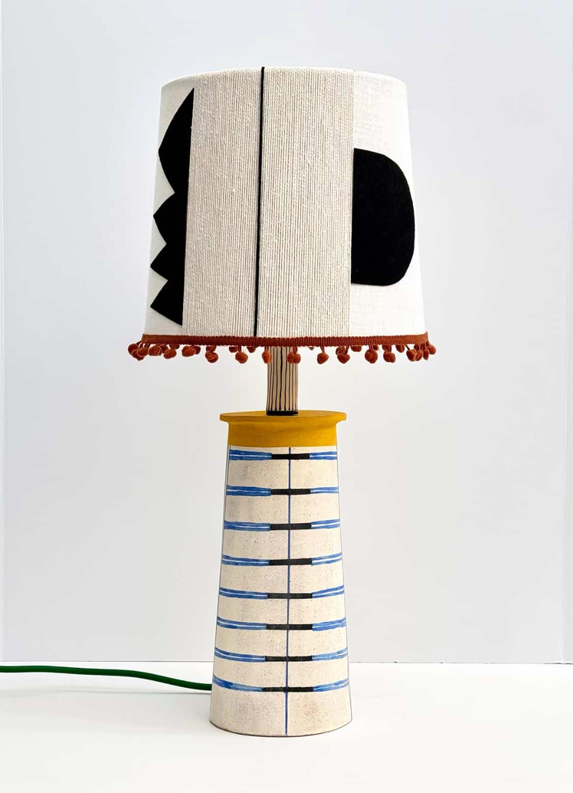 Colorful ceramic table lamp with abstract geometric design.