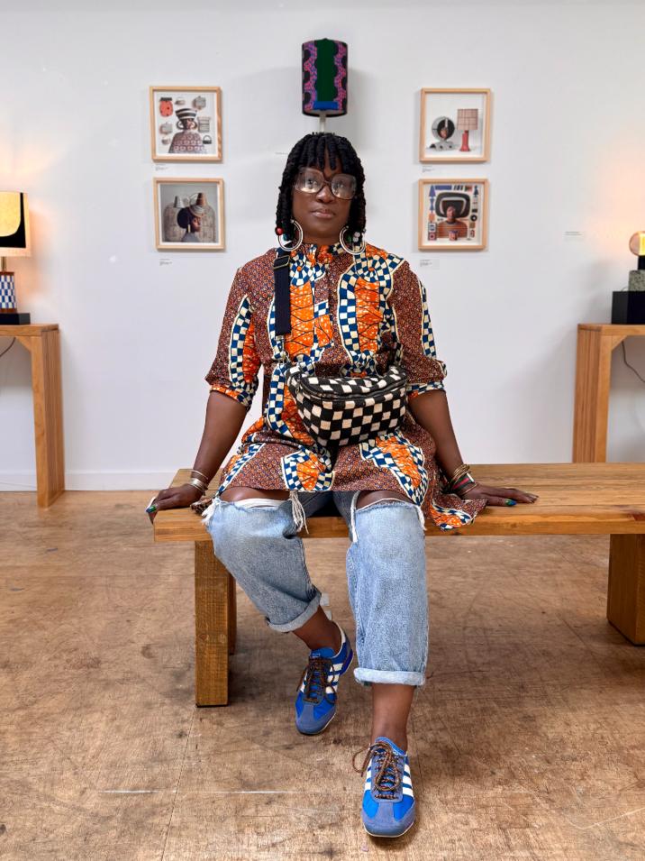 Artist Hadiya Williams standing beside her ceramic pieces, surrounded by guests during the exhibition closing reception.