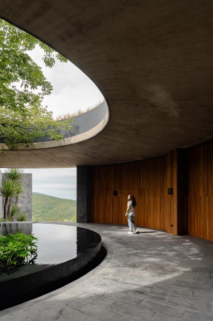 Circular floor plan with glazed façade opening toward the valley