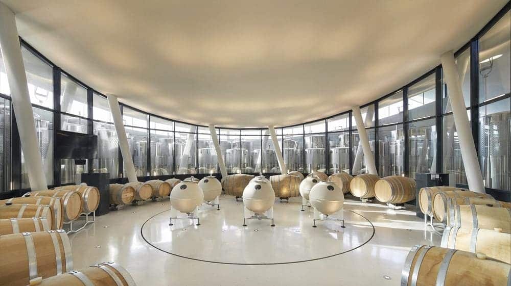 Circular fermentation hall with stainless steel tanks arranged concentrically around oak barrels