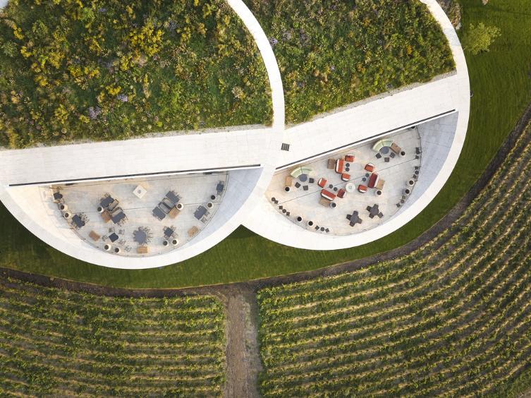 Lens-shaped Sauska Tokaj winery appears to float above hillside vineyards in Hungary