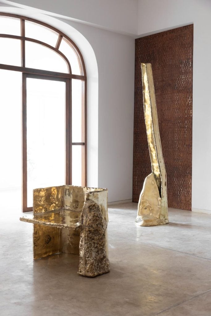 Armchair in heavy sand cast metal with raw finish