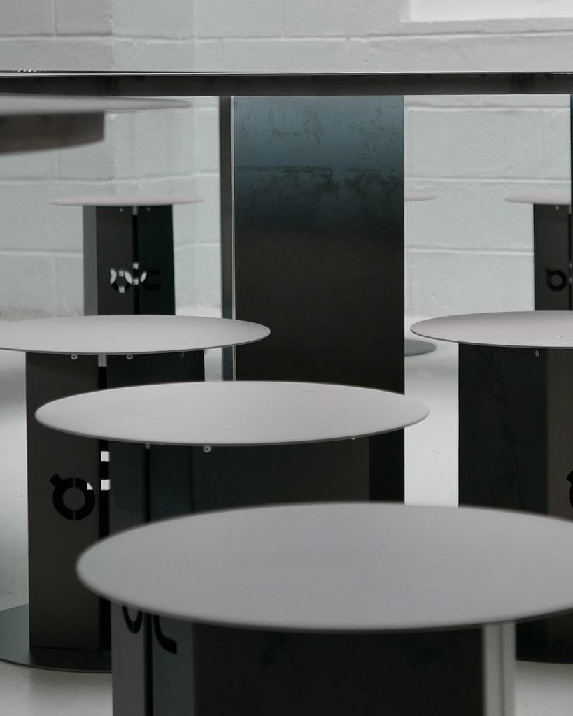 Brown steel stools with reactive finish matching the table