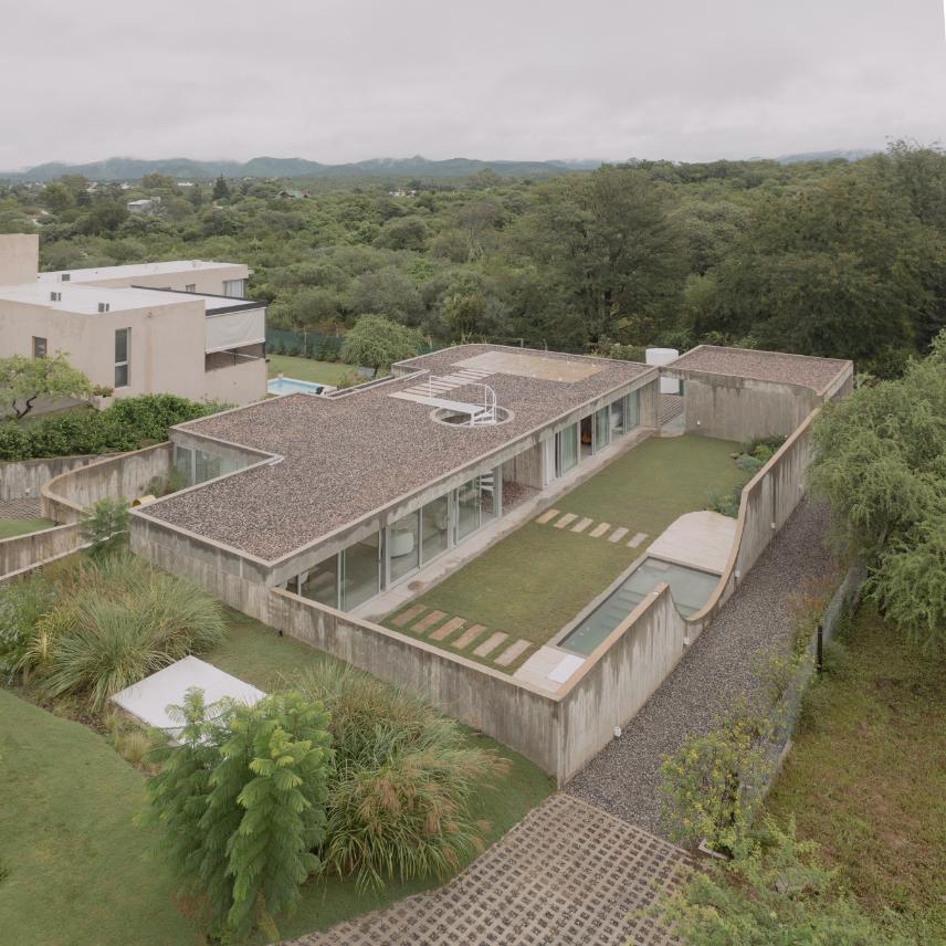 Casa Clausura illuminated softly at dusk within its suburban context