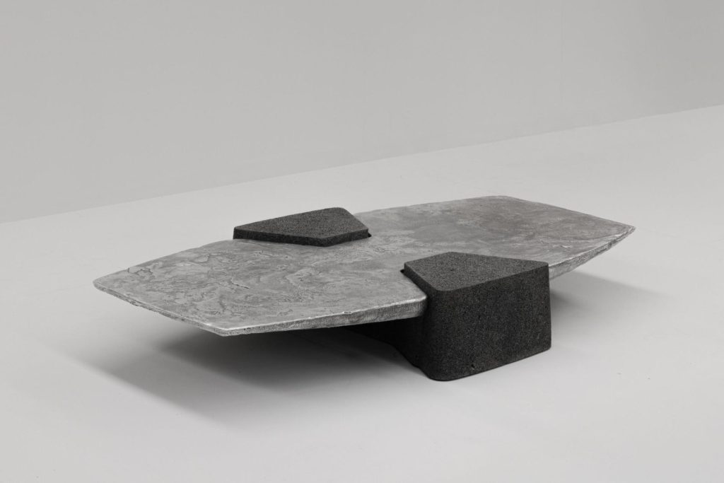 Polished coffee table surface reflecting light above rough stone