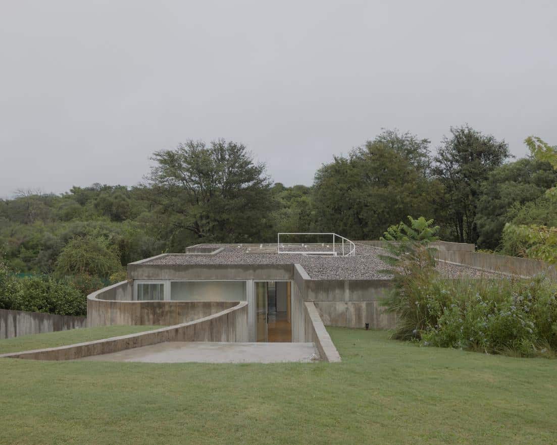 Concrete facade of Casa Clausura appearing level with the grassy mound in Córdoba