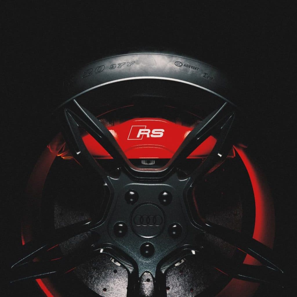 Audi four rings rendered in carbon fibre with cinematic lighting.