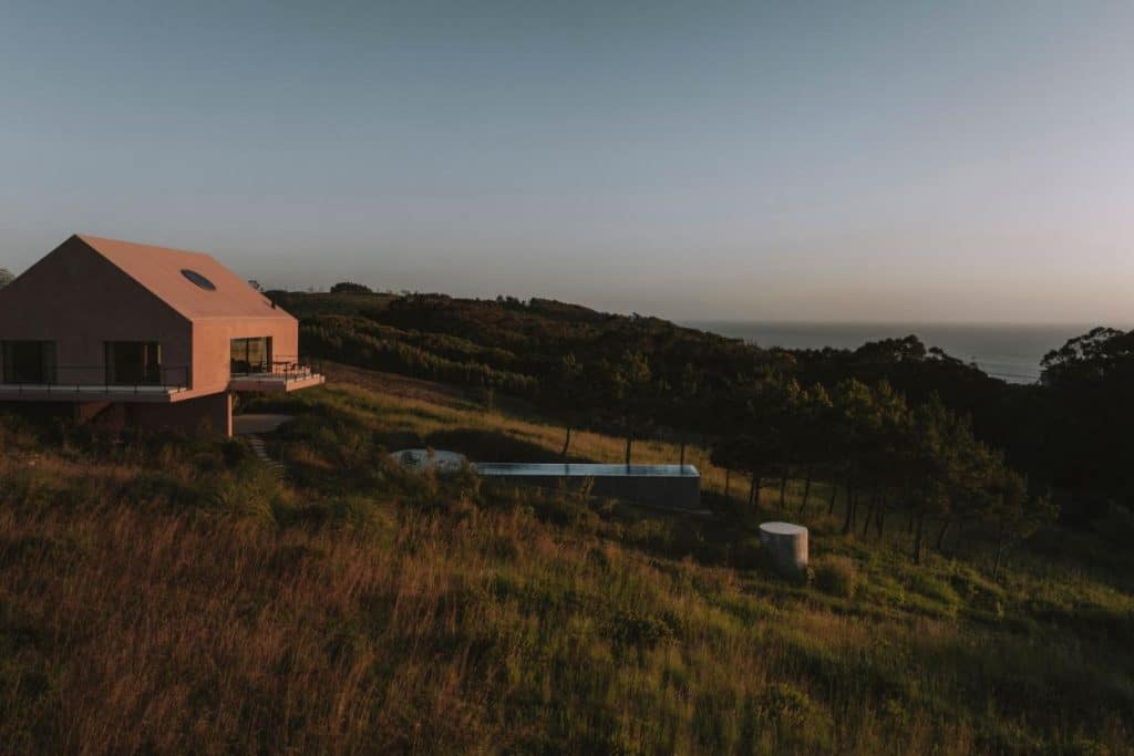Exterior view of Casa Plaj elevated above sloping land in Lourinhã