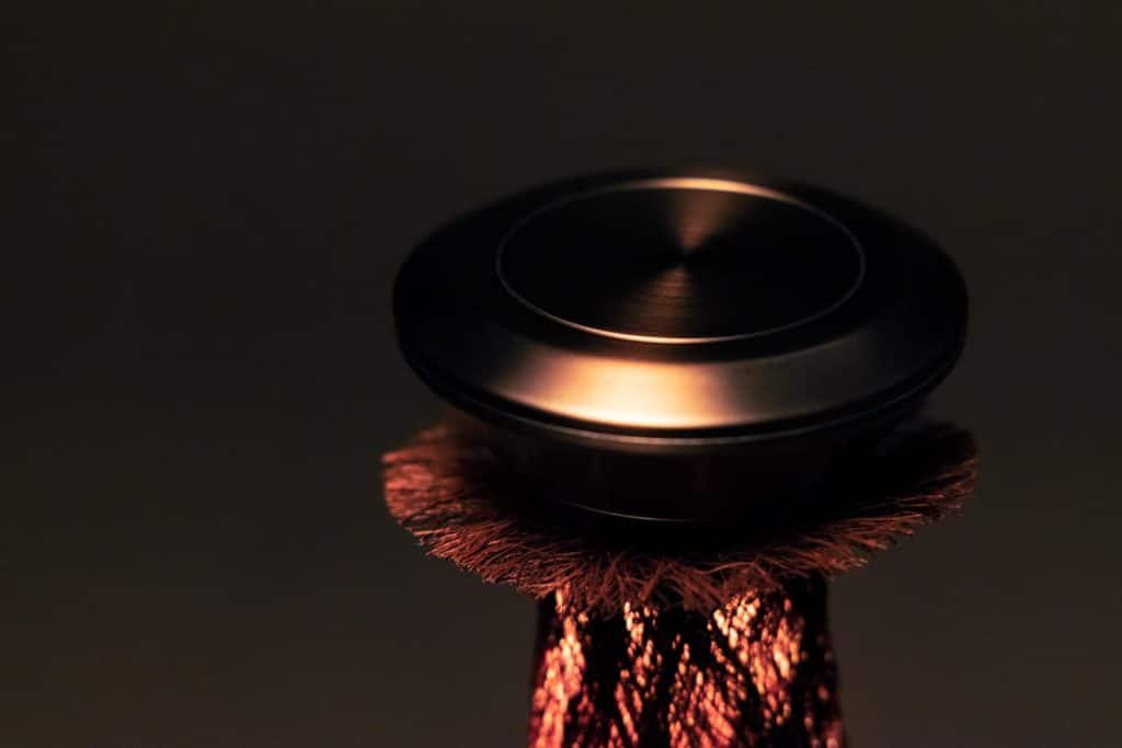 Houyou table lamp with metal cap anchoring light source above bark structure