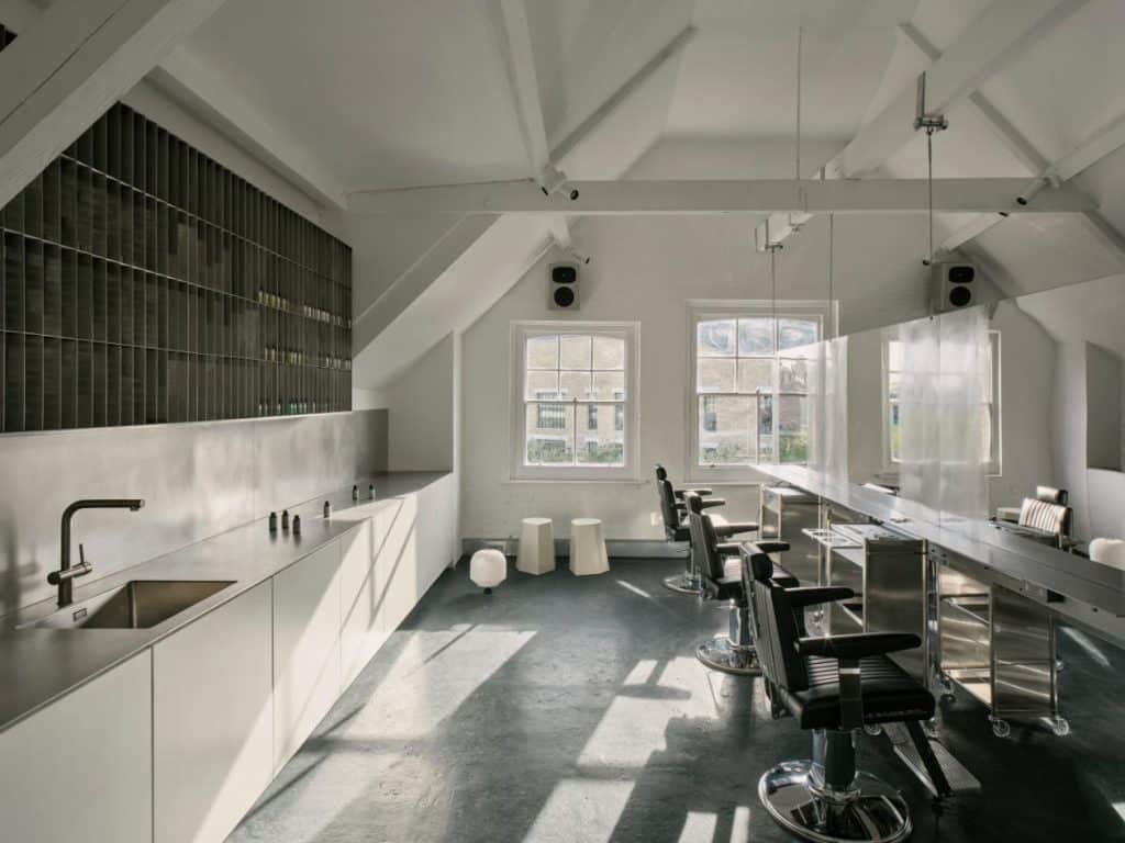 Hairdressing stations arranged around a central space with acoustic detailing