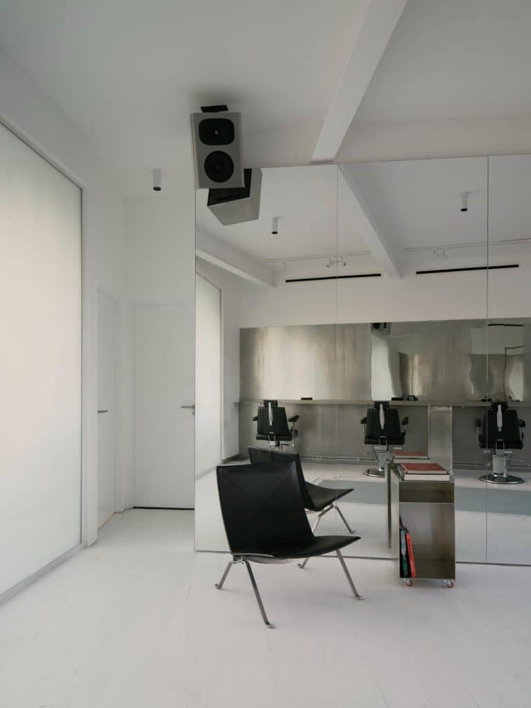 Hairdressing stations arranged around a central space with acoustic detailing
