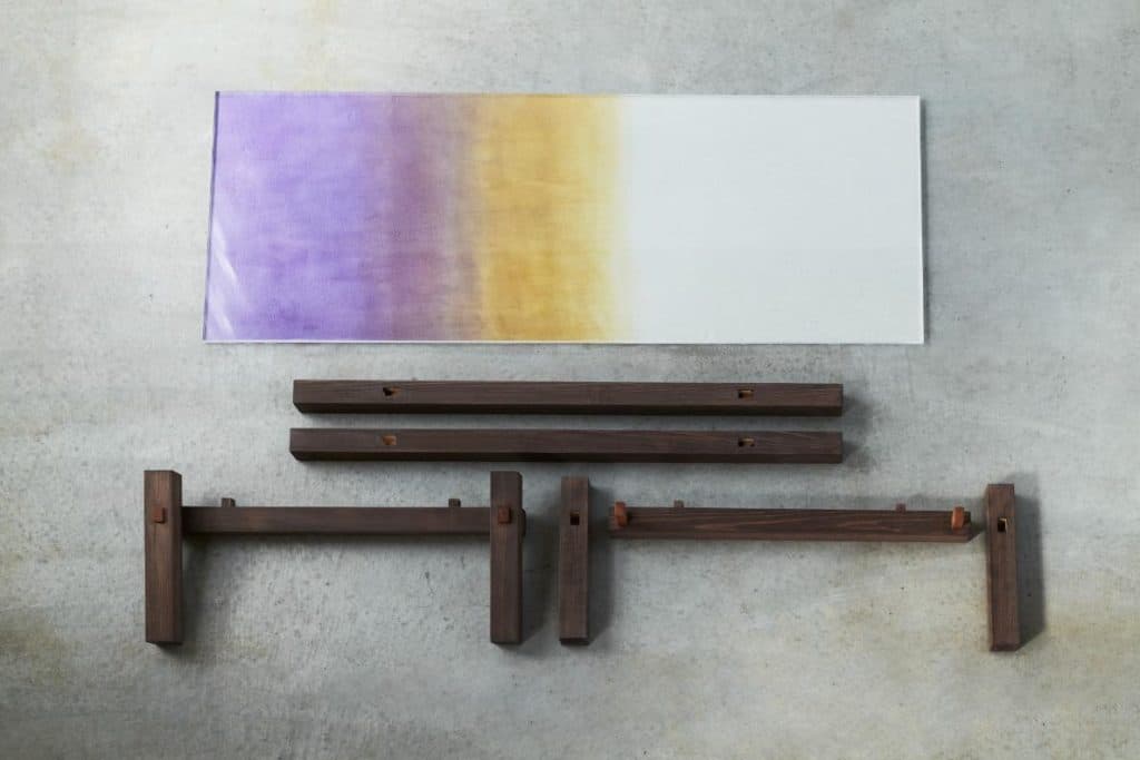 Wooden elements integrated with dyed paper in a minimal setting.