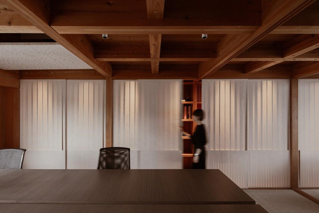 Timber ceiling with rotatable panels concealing ambient lighting
