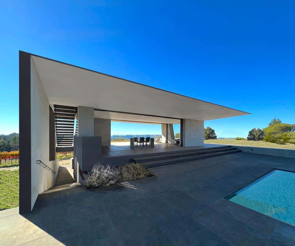 Concrete pavilion overlooking vineyards on a hillside
