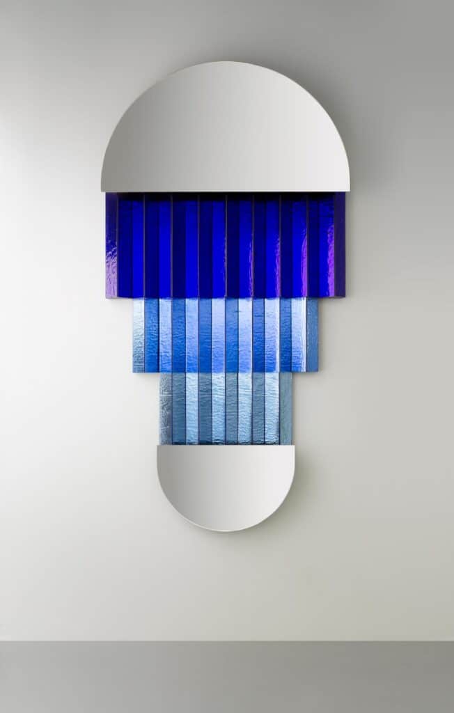 Murano glass mirror reflecting the colored geometry of Wilmotte’s new pieces