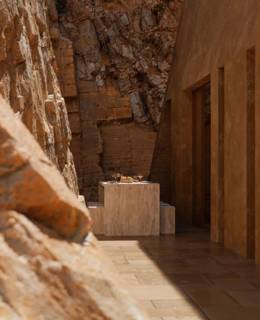 Textured concrete walls meeting natural stone terrain