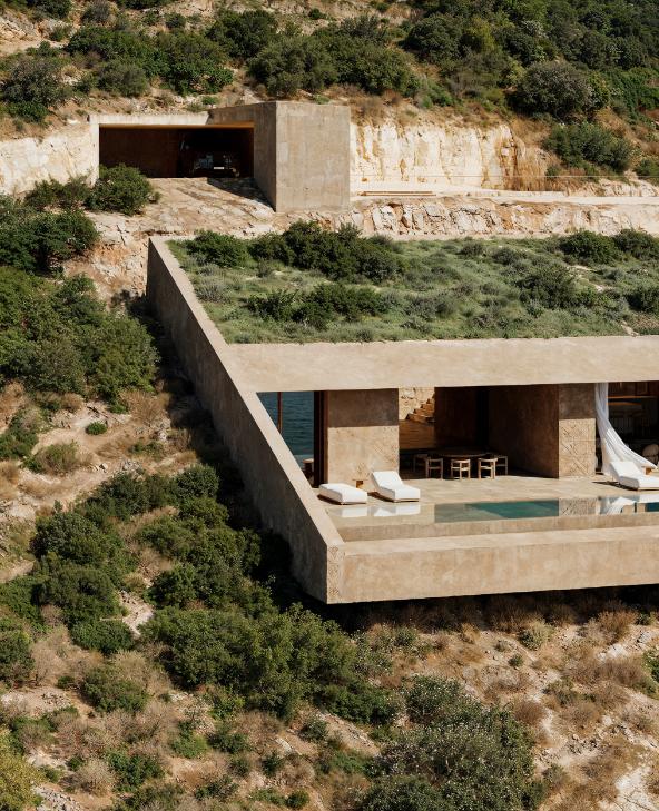 Concrete villa structure set against steep Albanian cliffs