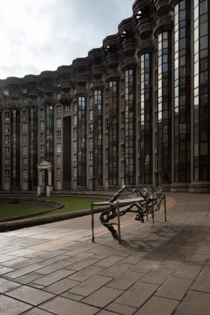 Monumental sculpture positioned within the geometric façade of Abraxas