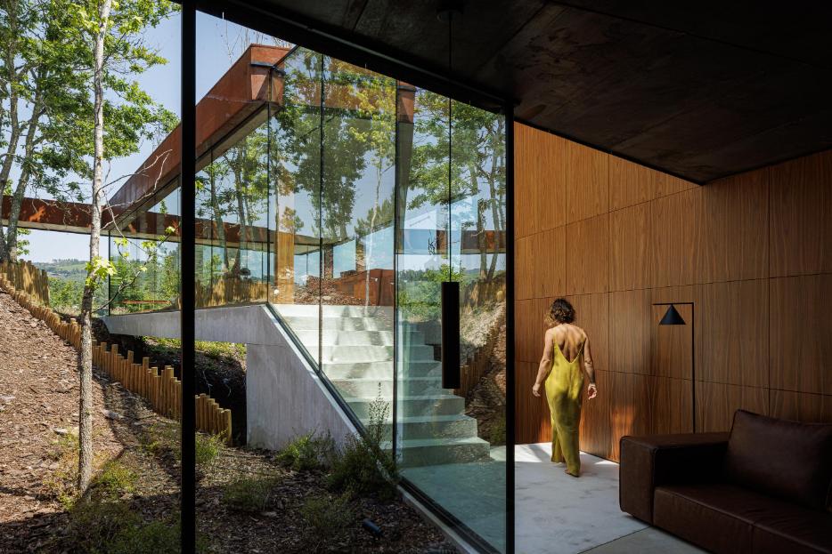 Casa Corten by HPA Arquitetura on a sloped industrial site -