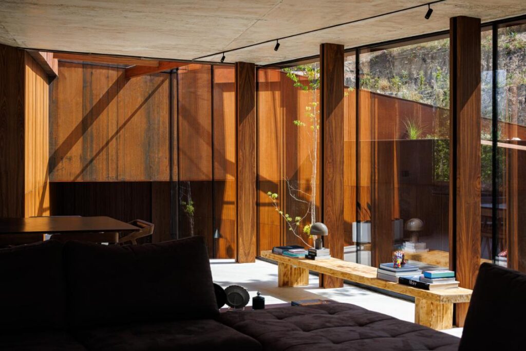 Casa Corten by HPA Arquitetura on a sloped industrial site -