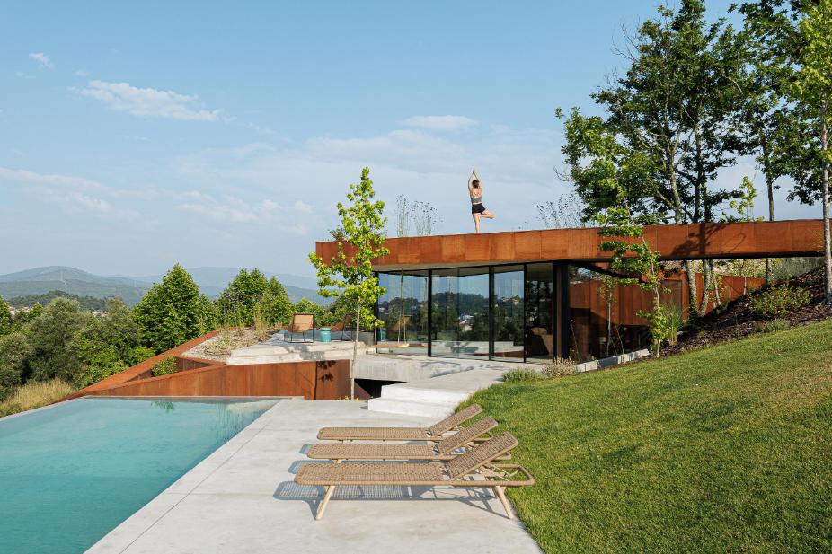 Casa Corten by HPA Arquitetura on a sloped industrial site -