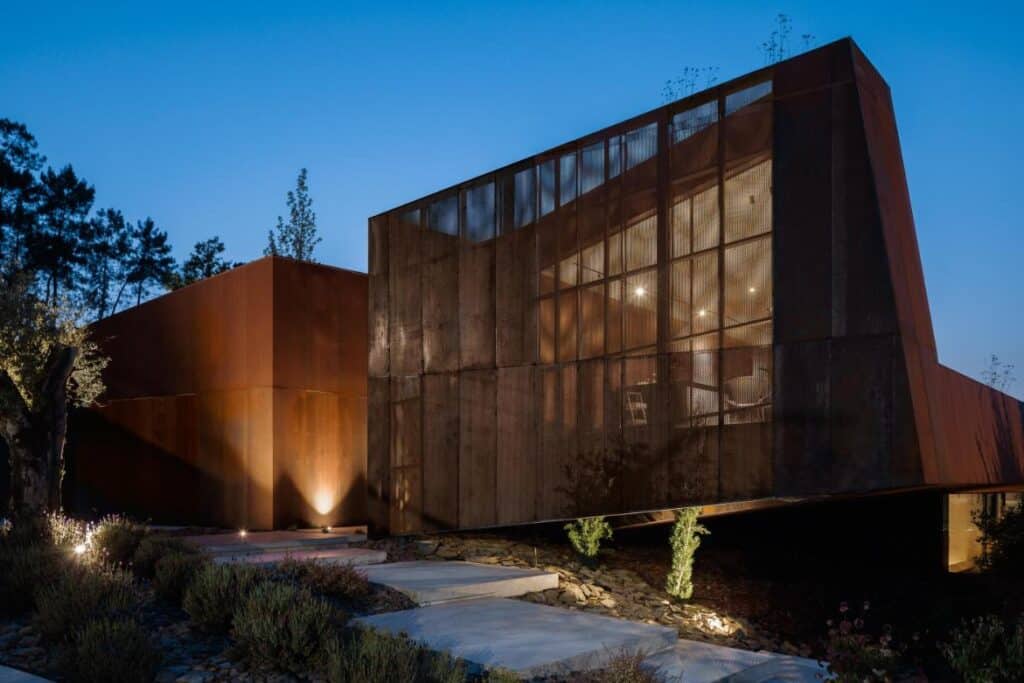 Casa Corten by HPA Arquitetura on a sloped industrial site -