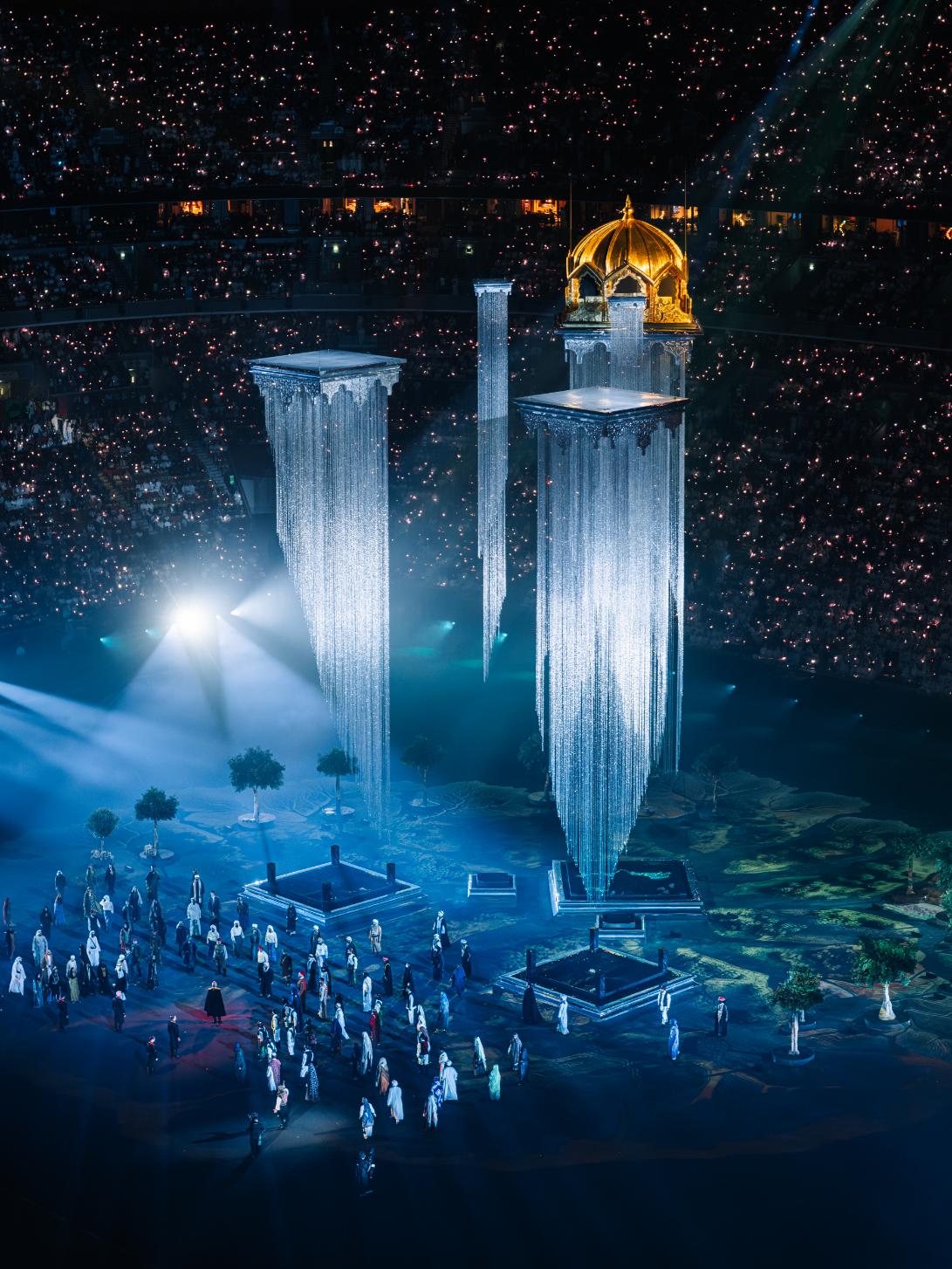 Performers moving around the central architectural structure during the show