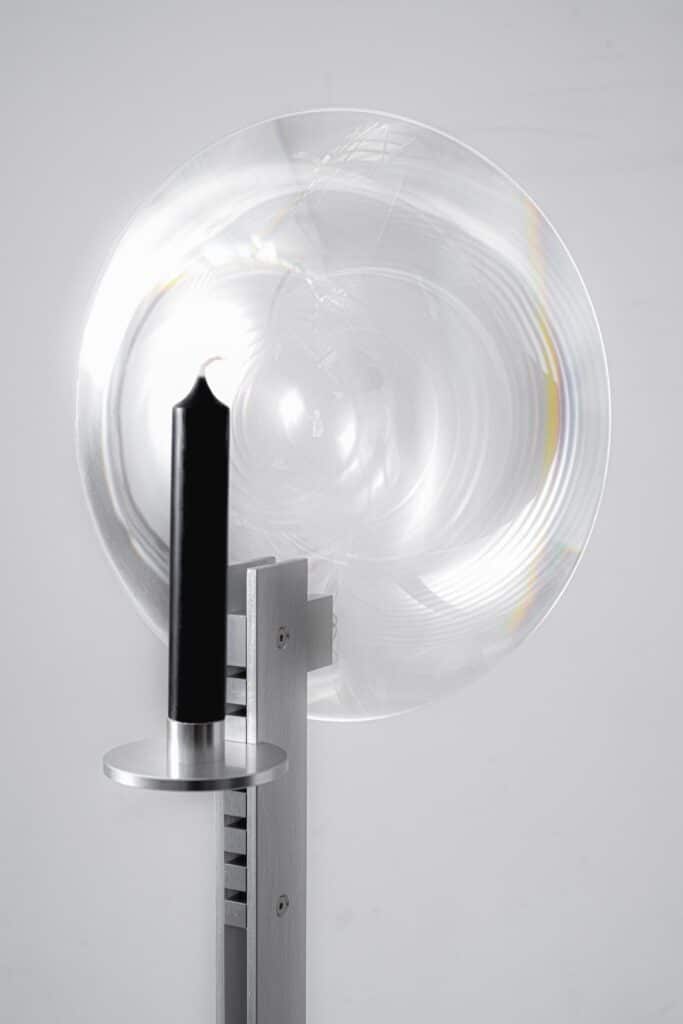 Optical lens focusing candle flame into a projected beam