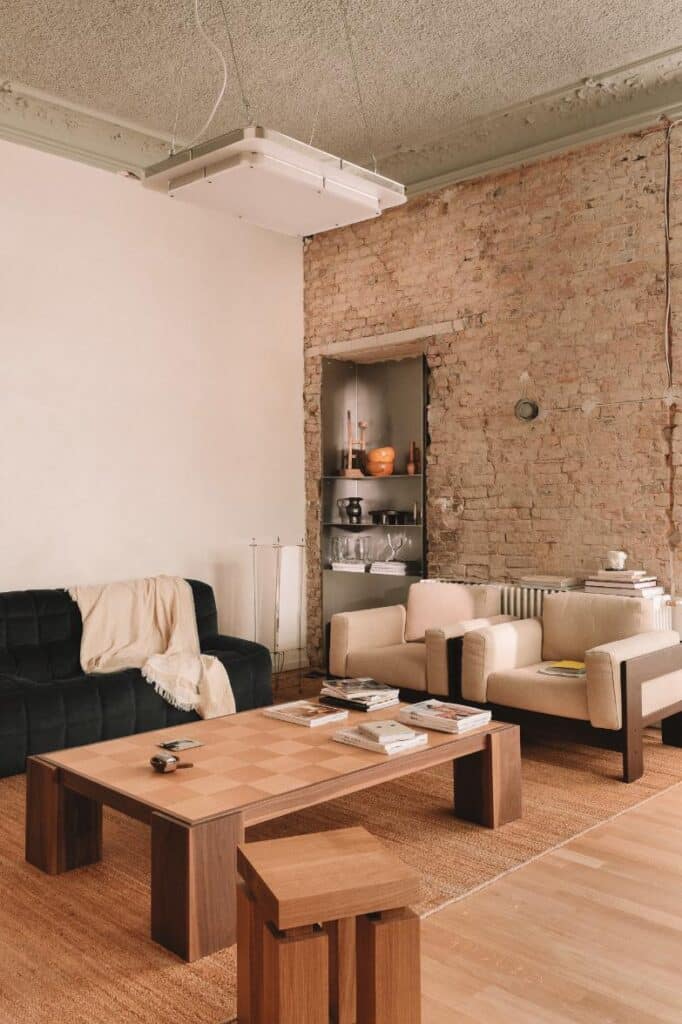Minimal meeting area combining raw architectural textures with precise custom furniture