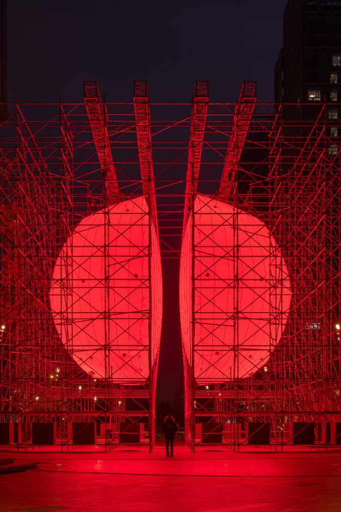 Close-up of the luminous sphere surface framed by scaffolding