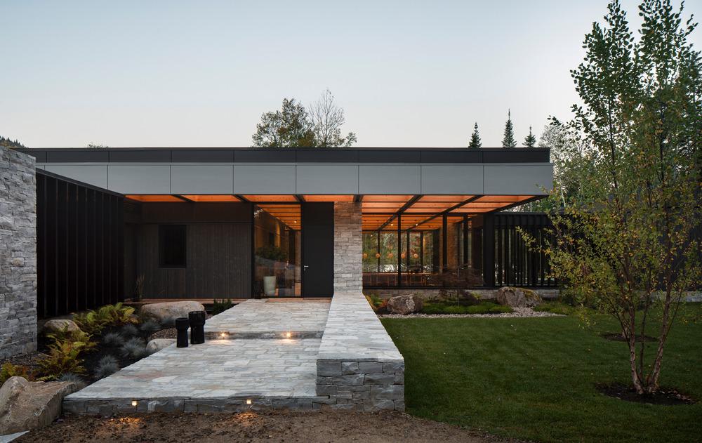 Exterior view of timber roof projecting toward Lac Archambault with forest backdrop