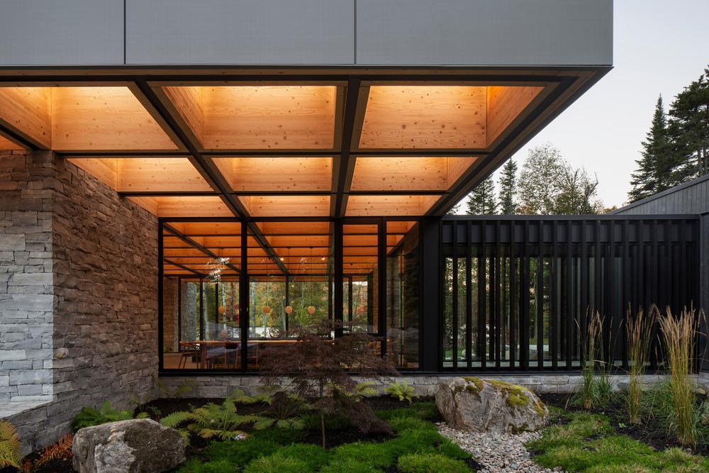 Stone walls extending into the ground forming exterior seating and circulation paths