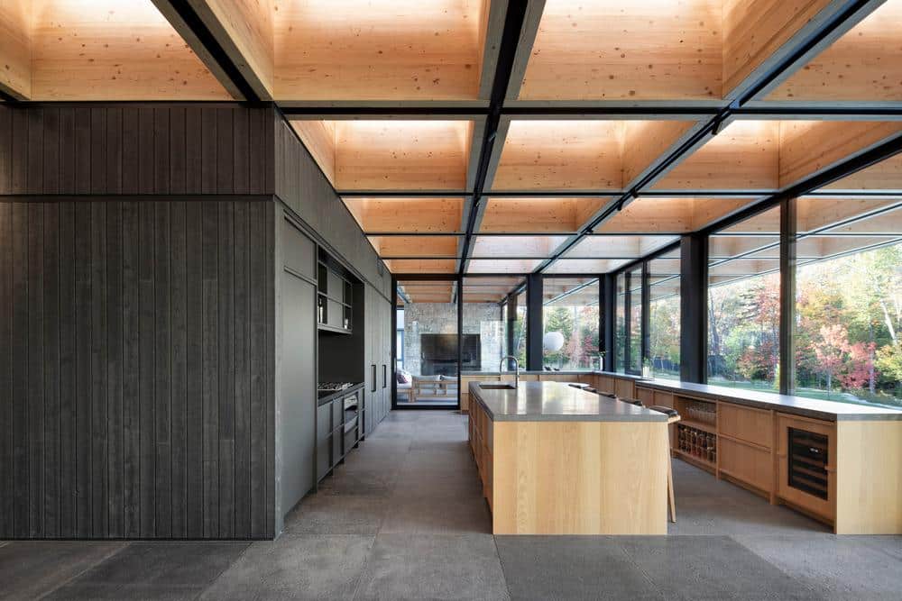 Kitchen and screened terrace connected through large sliding openings toward the forest